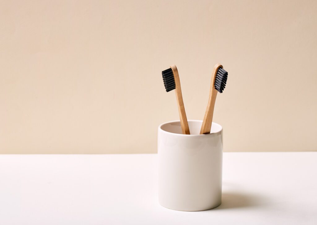 Two bamboo toothbrushes in a white holder